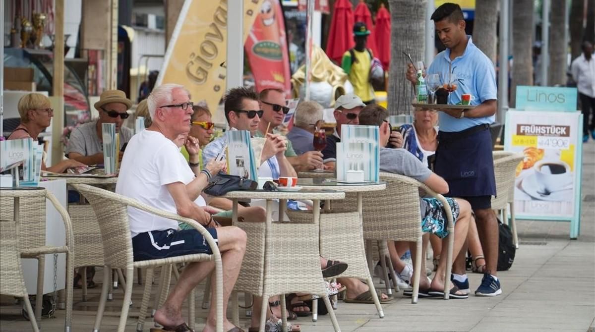 Un camarero atiende a unos turistas en una terraza de Palma de Mallorca. Un camarero atiende a unos turistas en una terraza de Palma de Mallorca.