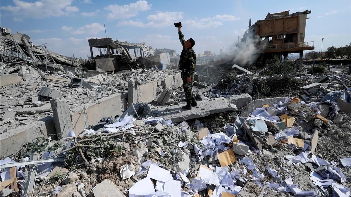 Un soldado sirio filma los escombros tras un ataque de las fuerzas estadounidenses, francesas y británicas el 14 de abril del 2018 para castigar al presidente Bashar el Asad por el uso de armas químicas contra civiles. Un soldado sirio filma los escombros tras un ataque de las fuerzas estadounidenses, francesas y británicas el 14 de abril del 2018 para castigar al presidente Bashar el Asad por el uso de armas químicas contra civiles.