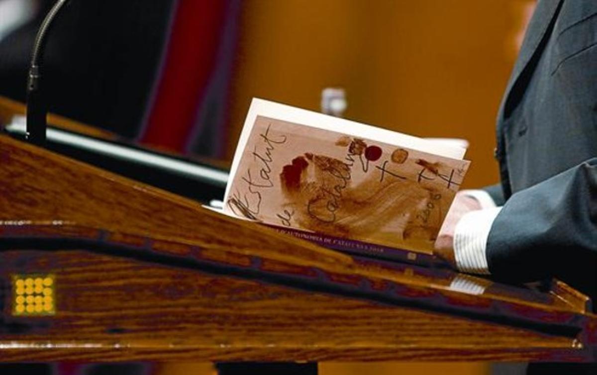 Artur Mas lee un ejemplar del Estatut de Catalunya, ayer en el Parlament durante la sesión de control al Govern.