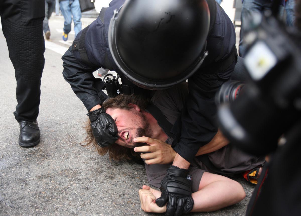 Un Mosso d’Esquadra placa e inmoviliza brutalmente a un participante en la acampada por el 15-M en el plaza de Catalunya. 