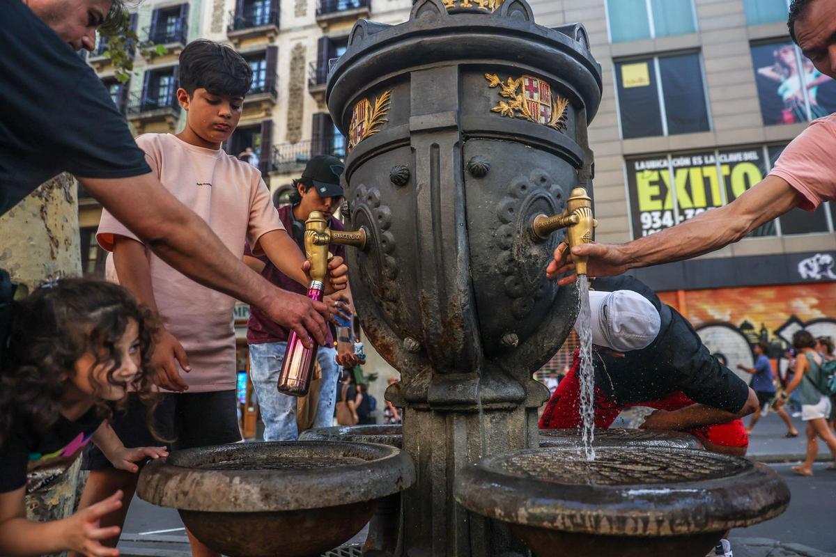 gente refrescandose en la fuente de canaletas por el calor