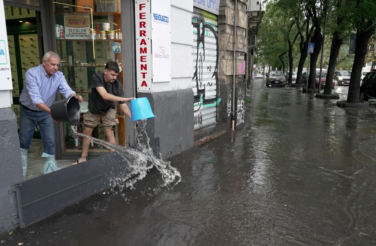 Los ciudadanos de Catania evacuan agua de sus casas y negocios. Los ciudadanos de Catania evacuan agua de sus casas y negocios.