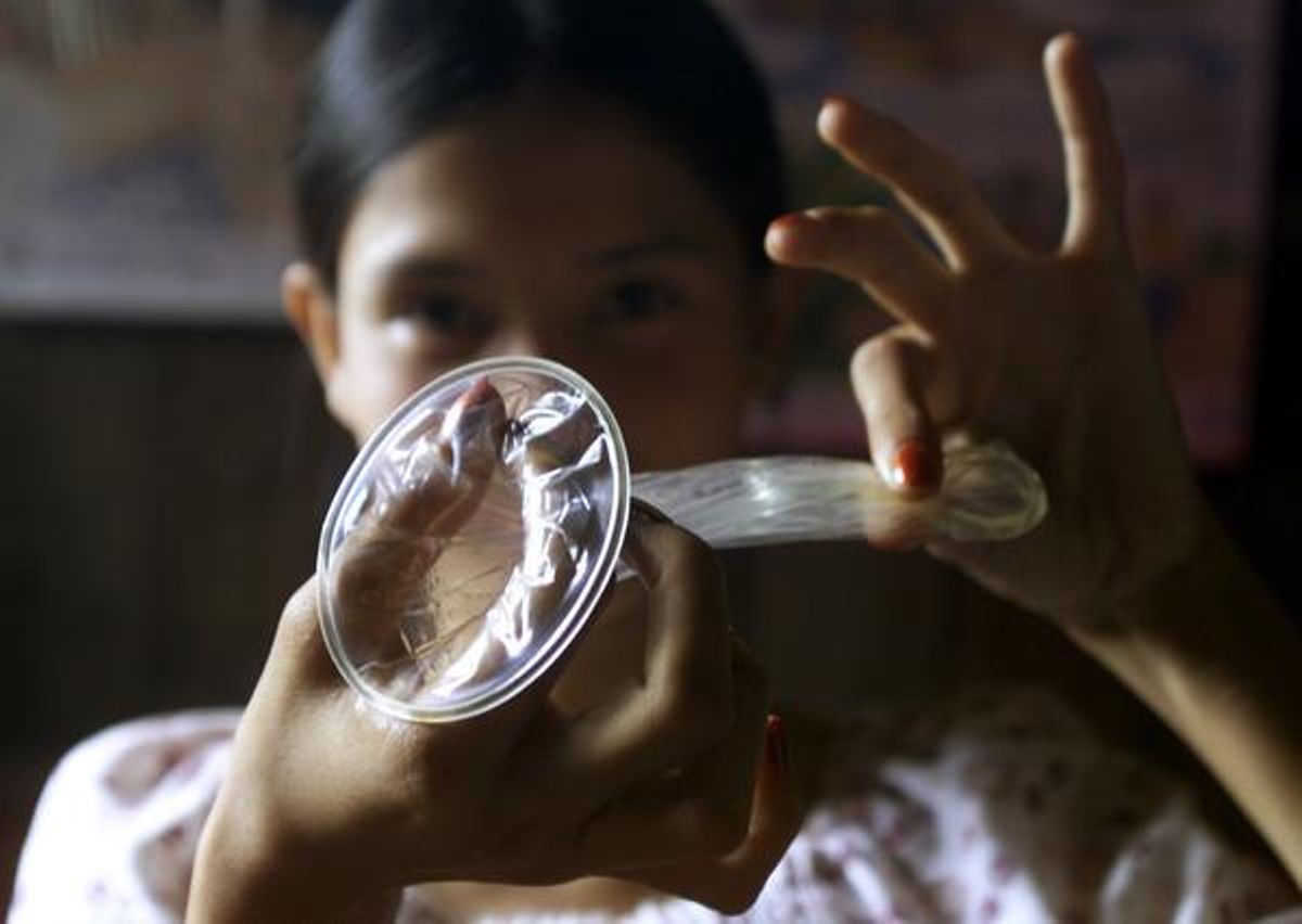 Una mujer sostiene un preservativo femenino. Una mujer sostiene un preservativo femenino.