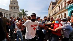 Policías arrestan a manifestantes frente al capitolio de Cuba, en La Habana.