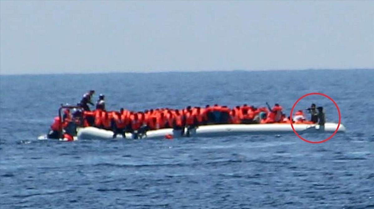 Imagen de la oenegé Jugen Rettet donde se ve a unos guardacostas libios apuntando a unos refugiados. Imagen de la oenegé Jugen Rettet donde se ve a unos guardacostas libios apuntando a unos refugiados.