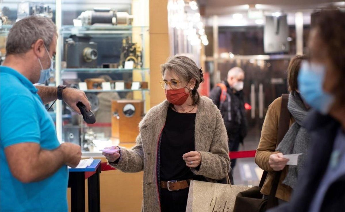 Una mujer con mascarilla valida su entrada en los cines Renoir de Barcelona. Una mujer con mascarilla valida su entrada en los cines Renoir de Barcelona.