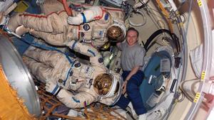 Estación Espacial Internacional (EEI), en la que se ve al cosmonauta Oleg V. Kotov, representante de la Agencia Espacial Rusa, sosteniendo dos trajes espaciales