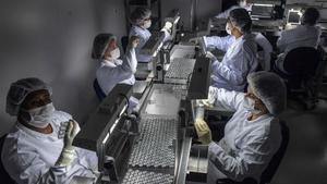 Empleados trabajan en la línea de producción de una vacuna contra el coronavirus covid-19