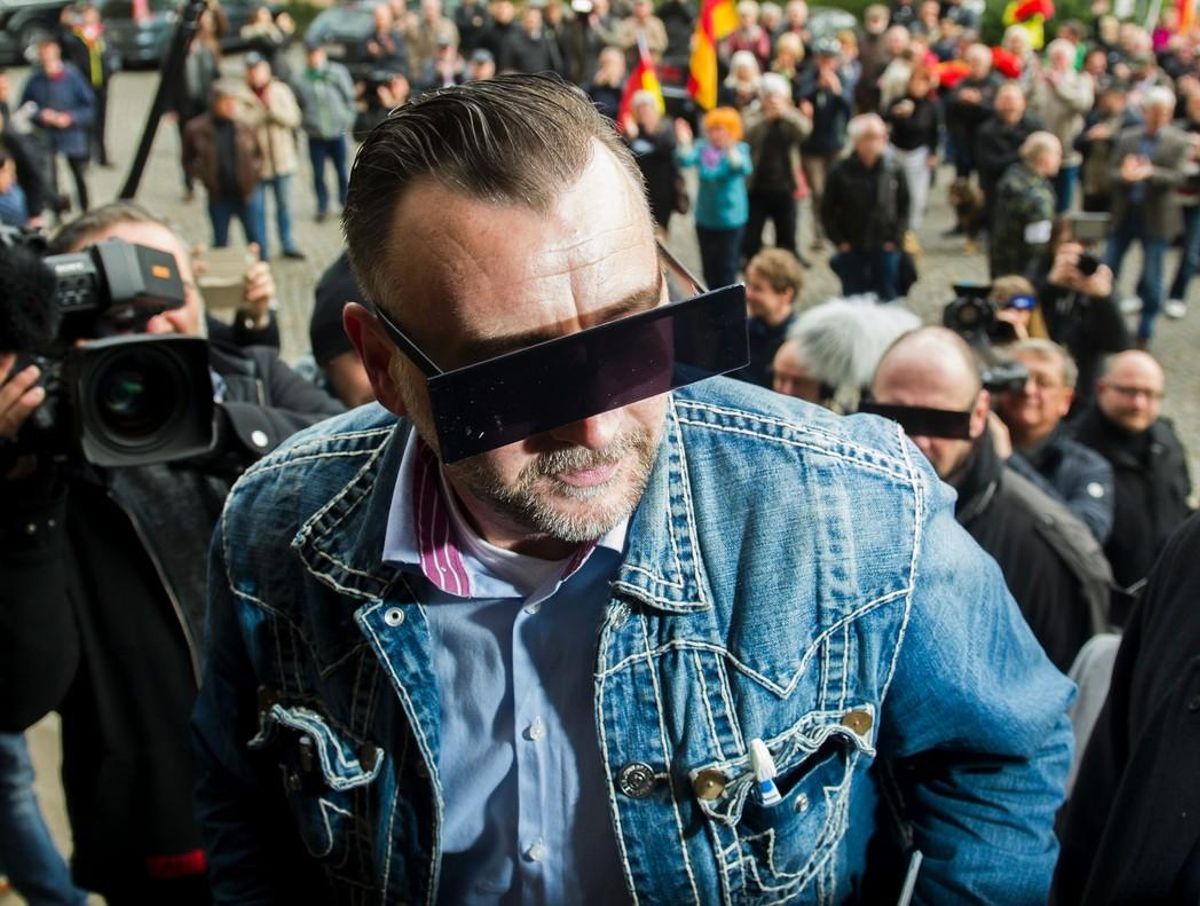 Lutz Bachmann, el fundador de PEGIDA, con los ojos tapados simulando un pixelado, a la entrada de los juzgados. Lutz Bachmann, el fundador de PEGIDA, con los ojos tapados simulando un pixelado, a la entrada de los juzgados.