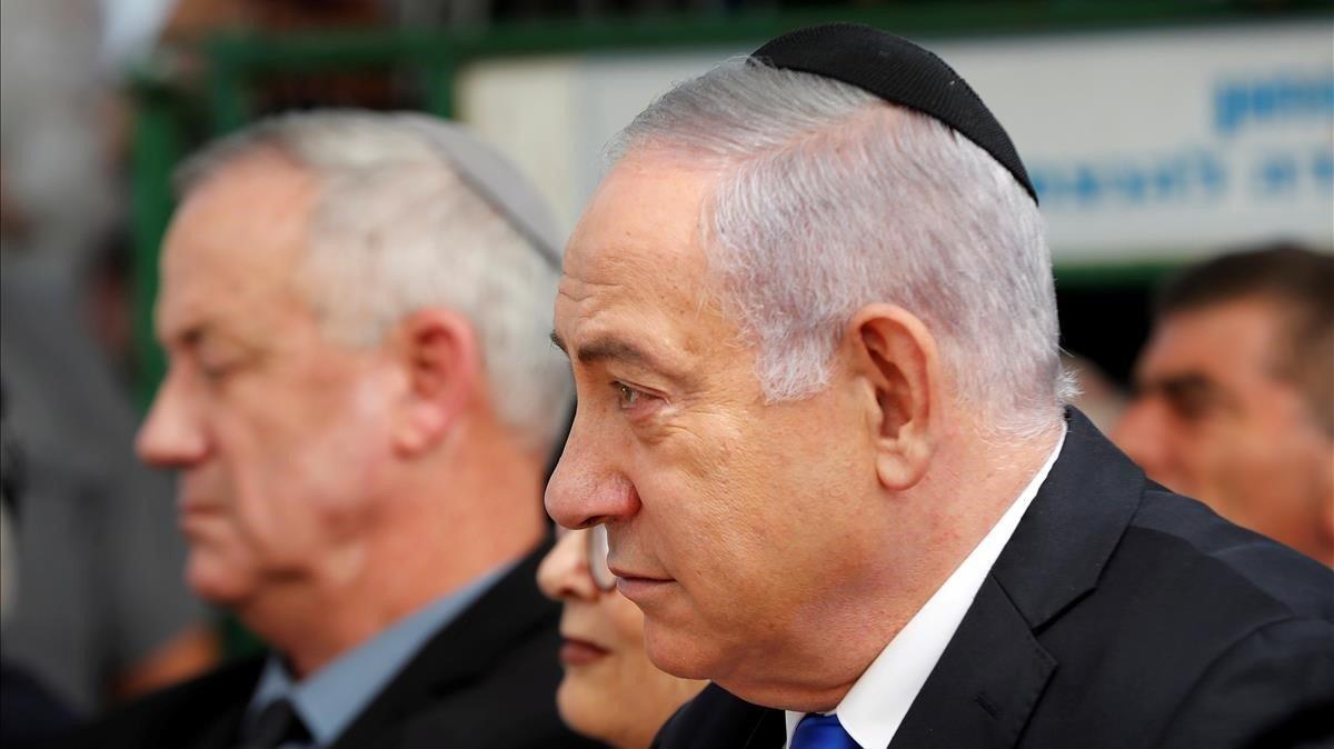 El primer ministro israelí, Binyamin Netanyahu, tocado con el kipá, y en segundo plano el líder del partido Azul y Blanco y ganador de las últimas elecciones, Benny Gantz.
