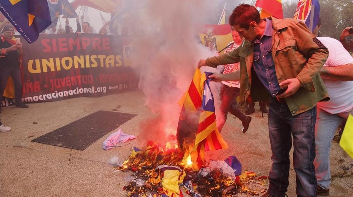 Varios manifestantes de la marcha ultra del 12-O en Barcelona queman una ’estelada’.