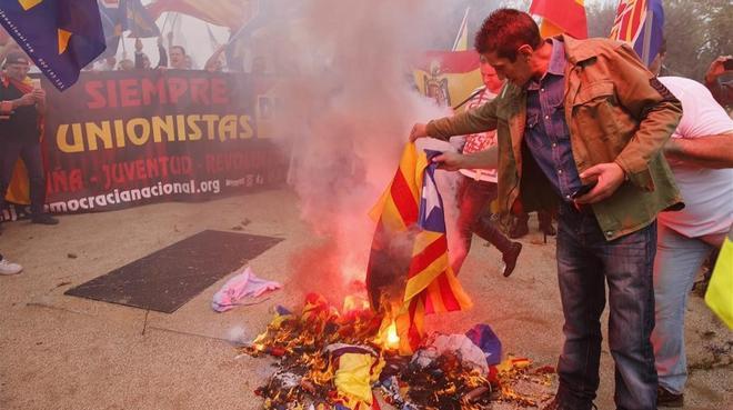 Varios manifestantes de la marcha ultra del 12-O en Barcelona queman una ’estelada’.