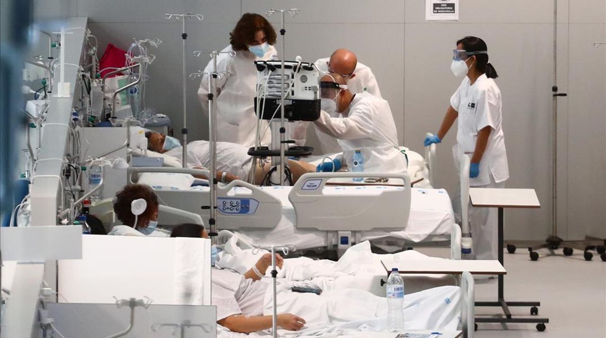 Unos doctores atienden este lunes a un paciente con coronavirus en el Hospital Enfermera Isabel Zendal en Madrid. Unos doctores atienden este lunes a un paciente con coronavirus en el Hospital Enfermera Isabel Zendal en Madrid.