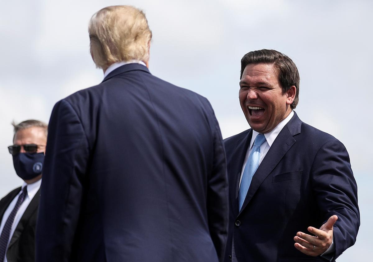 El expresidente Donald Trump saluda al gobernador de Florida, Ron DeSantis, a su llegada a Fort Myers para un acto de campaña en octubre de 2020.