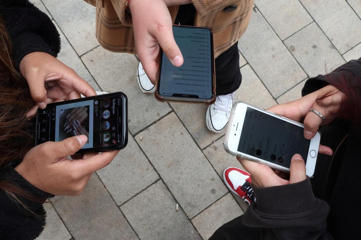 Adolescentes con sus móviles.