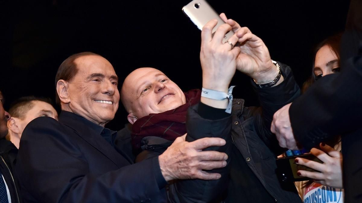Berlusconi (izquierda) posa para un selfi con un seguidor de Forza Italia, en Milán, el 25 de febrero. Berlusconi (izquierda) posa para un selfi con un seguidor de Forza Italia, en Milán, el 25 de febrero.
