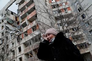 Una mujer pasa frente a un edificio destruido por las bombas rusas en la ciudad de Mariúpol.