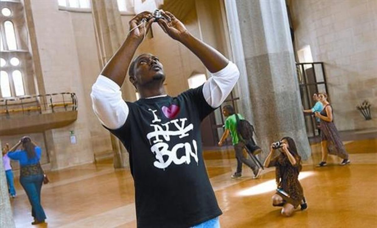 Turistas de diversas procedencias fotografían el singular techo de la nave central de la Sagrada Família, ayer. Turistas de diversas procedencias fotografían el singular techo de la nave central de la Sagrada Família, ayer.