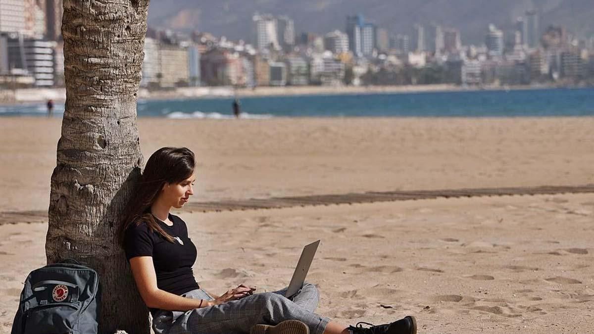Una joven inglesa trabaja desde la playa de Benidorm con su ordenador, una de las posibilidades que tienen los «nómadas digitales». Una joven inglesa trabaja desde la playa de Benidorm con su ordenador, una de las posibilidades que tienen los «nómadas digitales».
