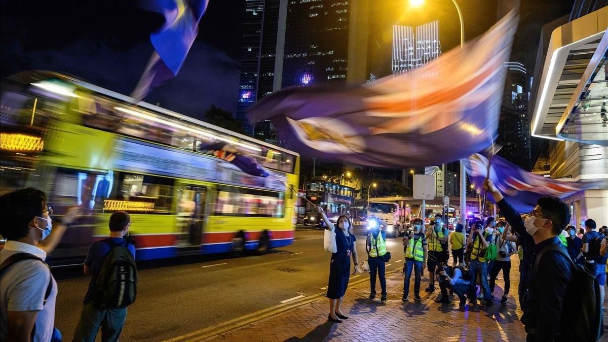Manifestantes antigubernamentales ondean la vieja bandera colonial durante una vigilia en Hong Kong, este viernes. Manifestantes antigubernamentales ondean la vieja bandera colonial durante una vigilia en Hong Kong, este viernes.