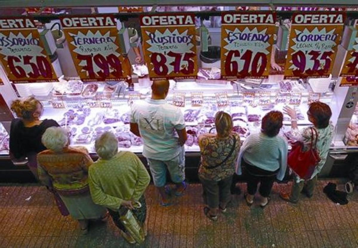 Clientes en una carnicería en un mercado de Barcelona.