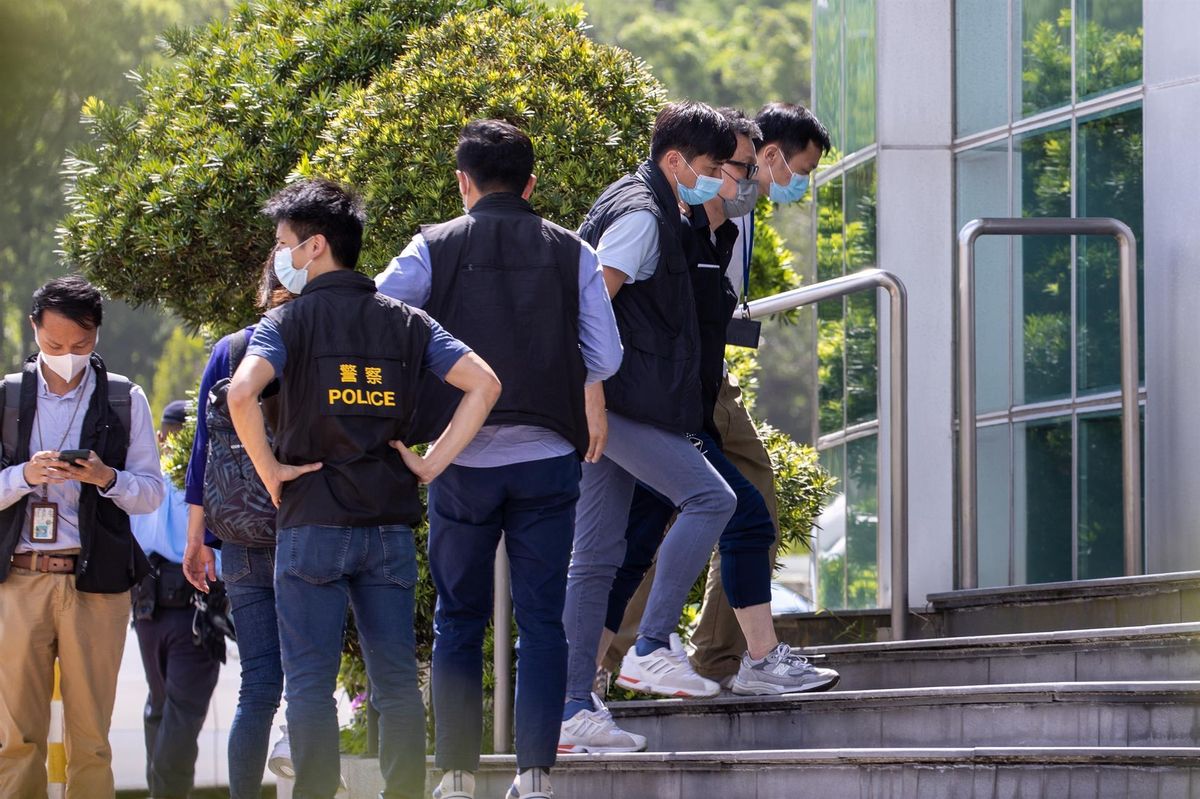 Cheung Chi Wai, del Apple Daily, esposado y escoltado por la policía de Hong Kong. Cheung Chi Wai, del Apple Daily, esposado y escoltado por la policía de Hong Kong.