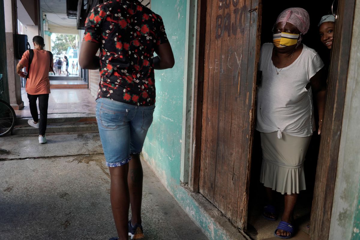 Una mujer mira desde la puerta en La Habana. Una mujer mira desde la puerta en La Habana.