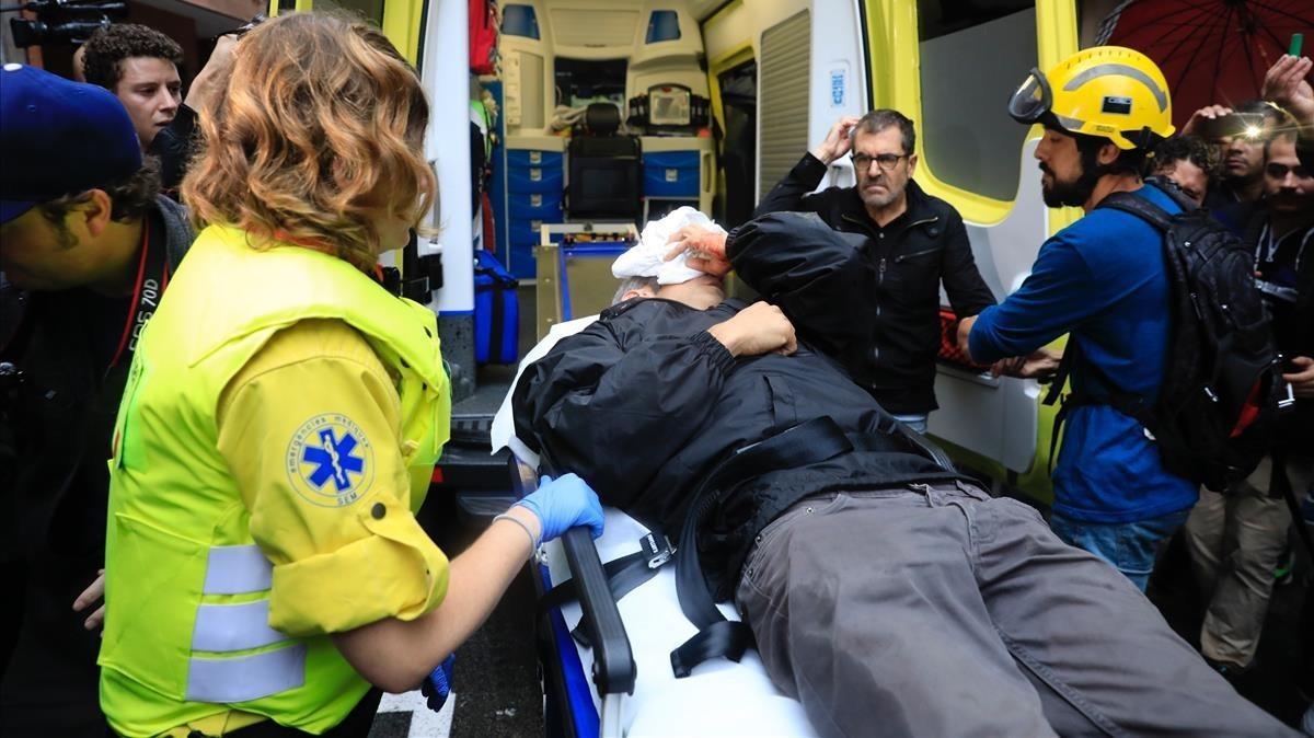 Roger Español es atendido por los servicios de emergencias tras ser herido por una pelota de goma durante la carga policial en la escuela Ramon Llull el 1-O.