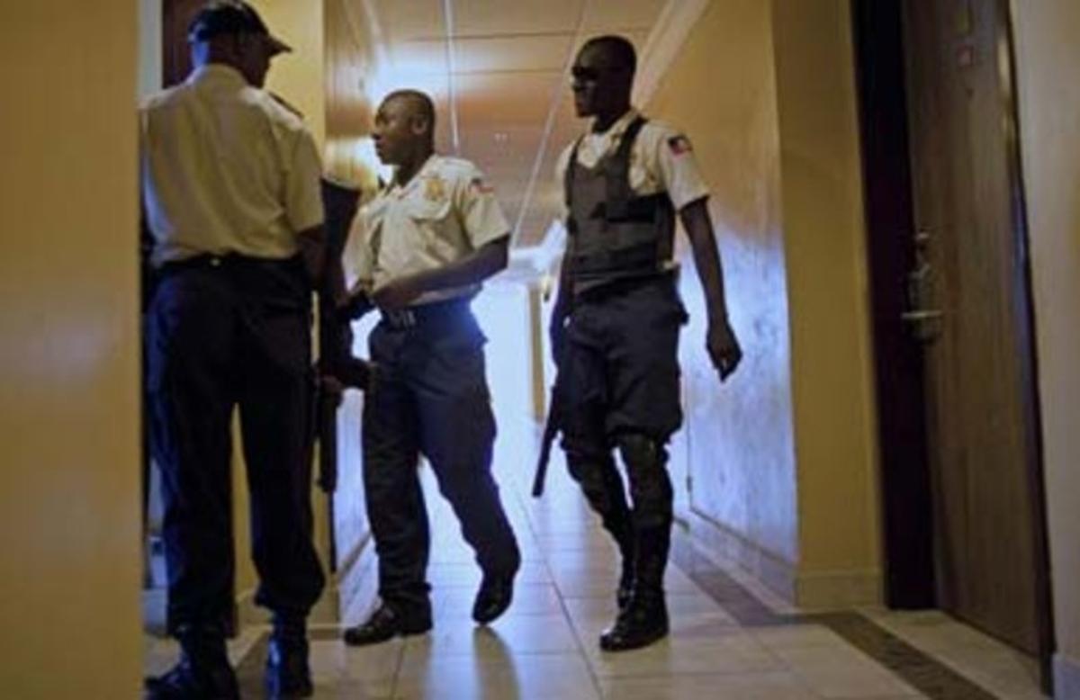 Agentes de policía patrullan el pasillo donde se encuentra la habitación del hotel donde se aloja el exdictador Duvalier en el hotel.
