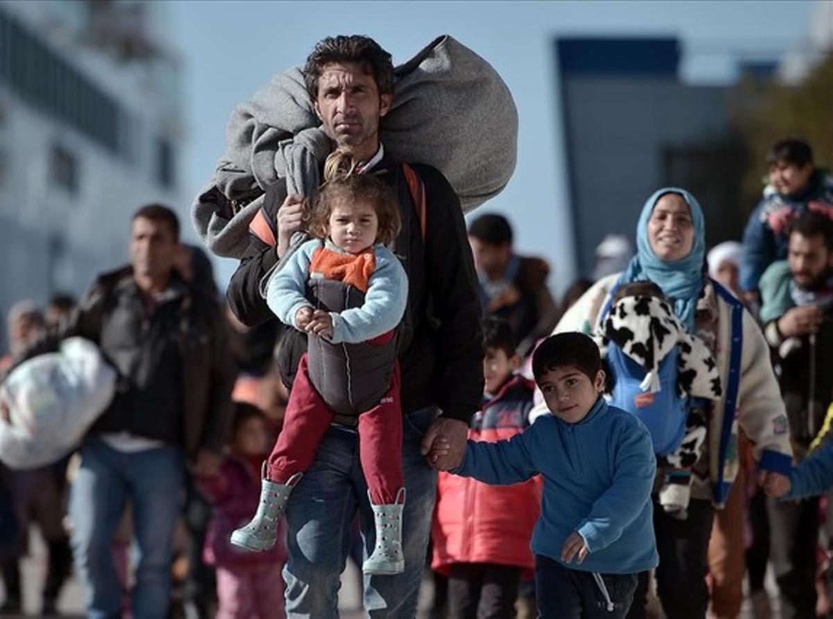 Llegada al puerto del Pireo de un grupo de inmigrantes con niños procedentes de Lesbos y Chios, el lunes.