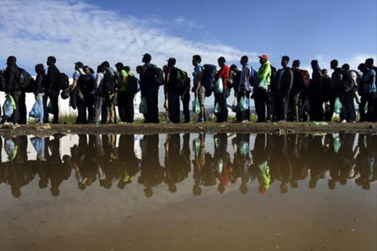 Refugiados esperan para obtener el permiso para dirigirse a una estación de trenes en un campo cerca de Gevgelija, en Macedonia, este lunes.
