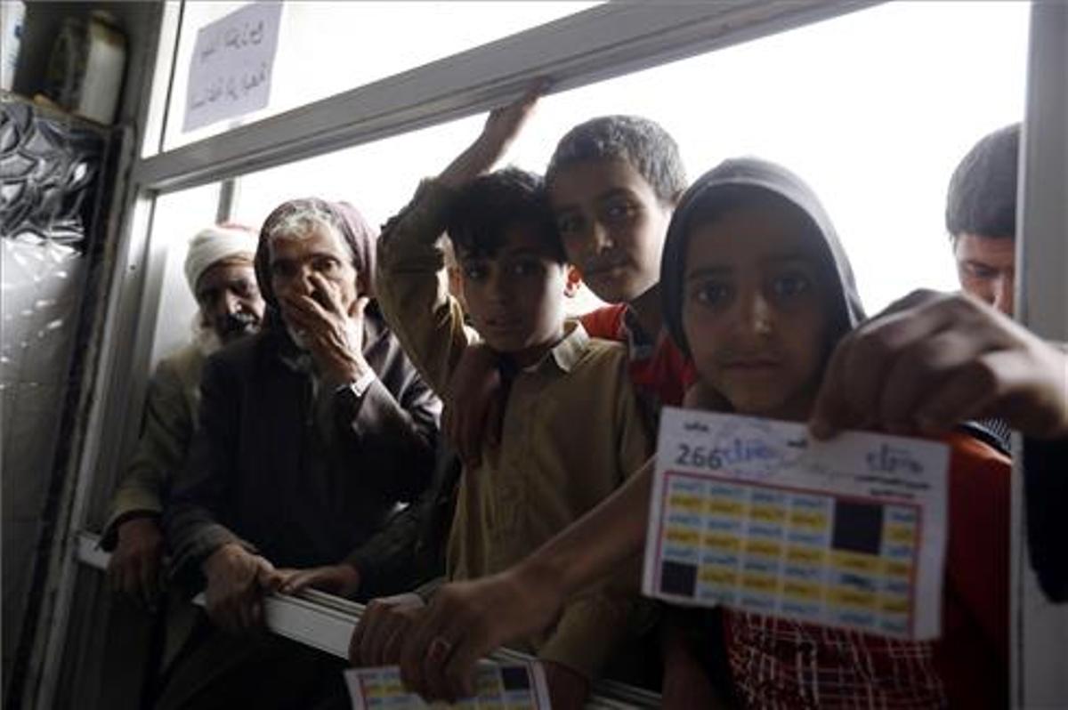 Yemeníes esperan para recibir la ayuda alimentaria de sus familias  romper el ayuno diario del Ramadán.