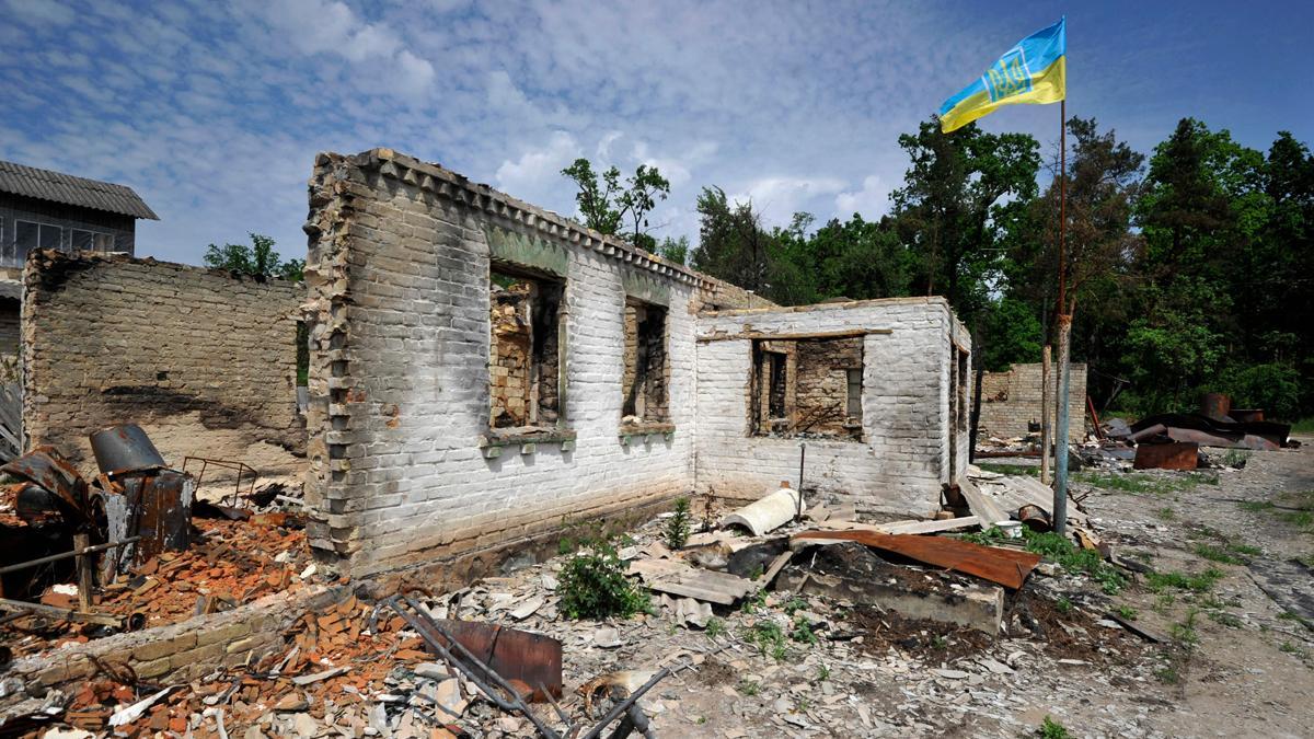 Una bandera ucraniana ondea sobre una casa destruida por bombardeos rusos en la localidad de Moshchun.