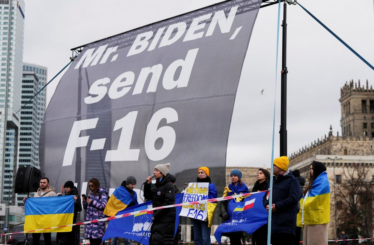 Ciudadanos polacos piden F-16 para Ucrania delante del hotel donde se hospeda Joe Biden en Varsovia.