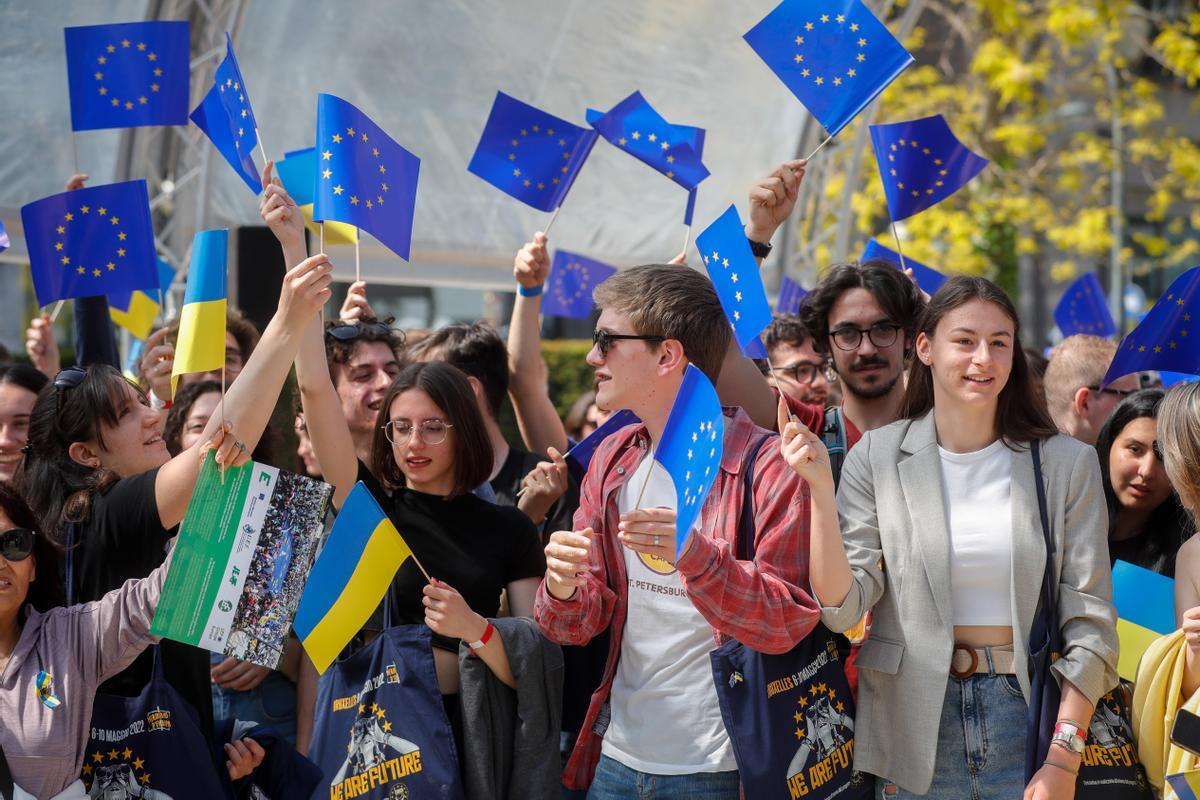 Jóvenes con banderas de la UE y de Ucrania durante un acto en Bruselas, este lunes.