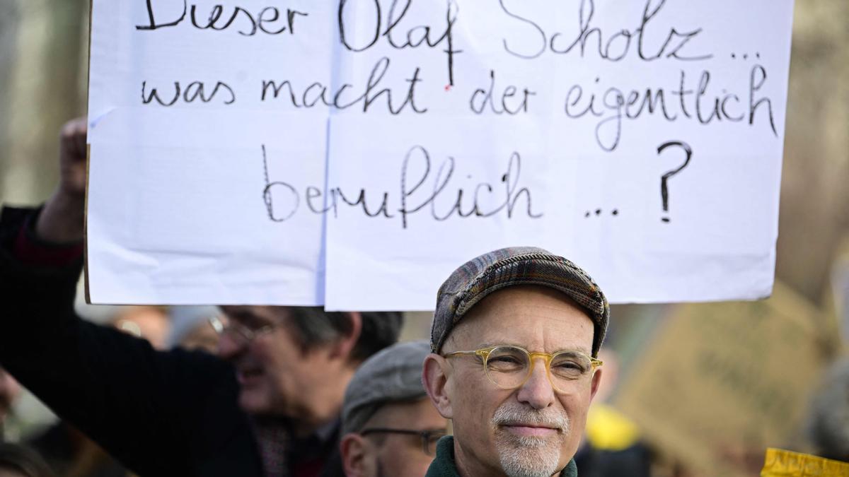Un activista sostiene una pancarta increpando al canciller Scholz por no cumplir sus objetivos ambientales.