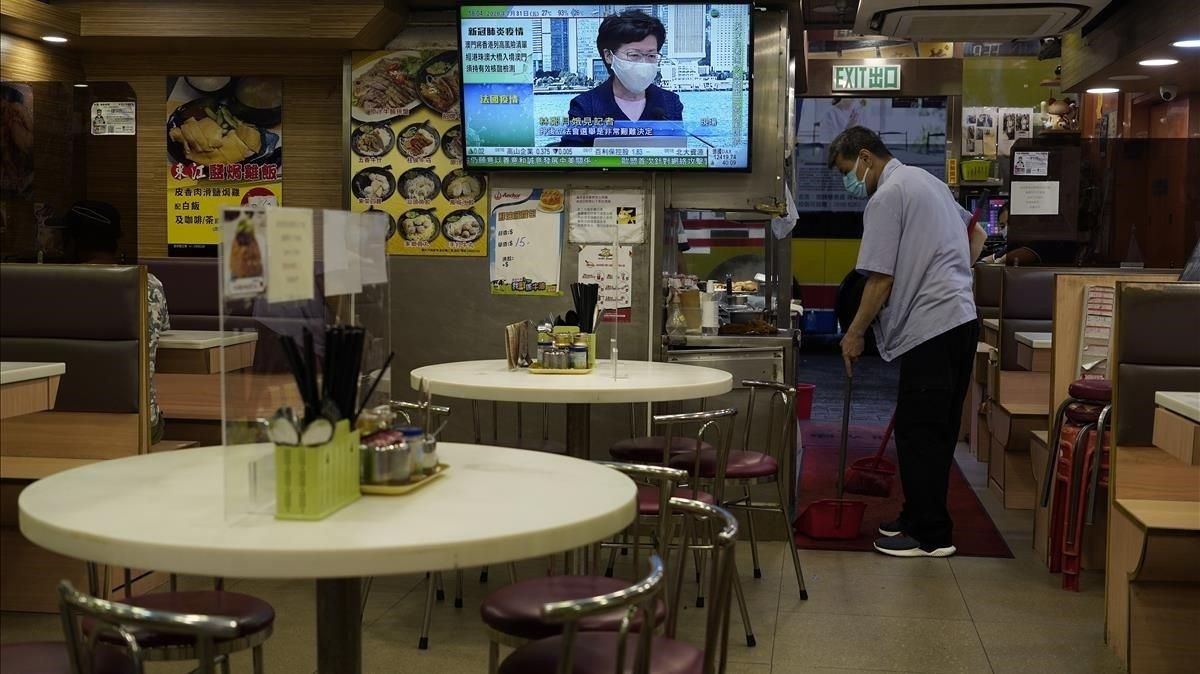 Un empleado de un restaurante limpia el local mientras la jefe del ejecutivo de Hong Kong, Carrie Lam, anuncia por televisión el aplazamiento de las elecciones. Un empleado de un restaurante limpia el local mientras la jefe del ejecutivo de Hong Kong, Carrie Lam, anuncia por televisión el aplazamiento de las elecciones.