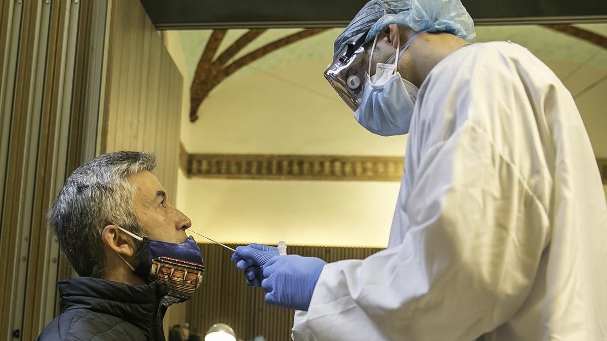 Un sanitario realizando un test PCR en Barcelona Un sanitario realizando un test PCR en Barcelona