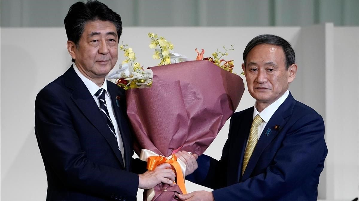 Suga (derecha) recibe un ramo de flores tras convertirse en el lider del partido gubernamental de Japón. Suga (derecha) recibe un ramo de flores tras convertirse en el lider del partido gubernamental de Japón.