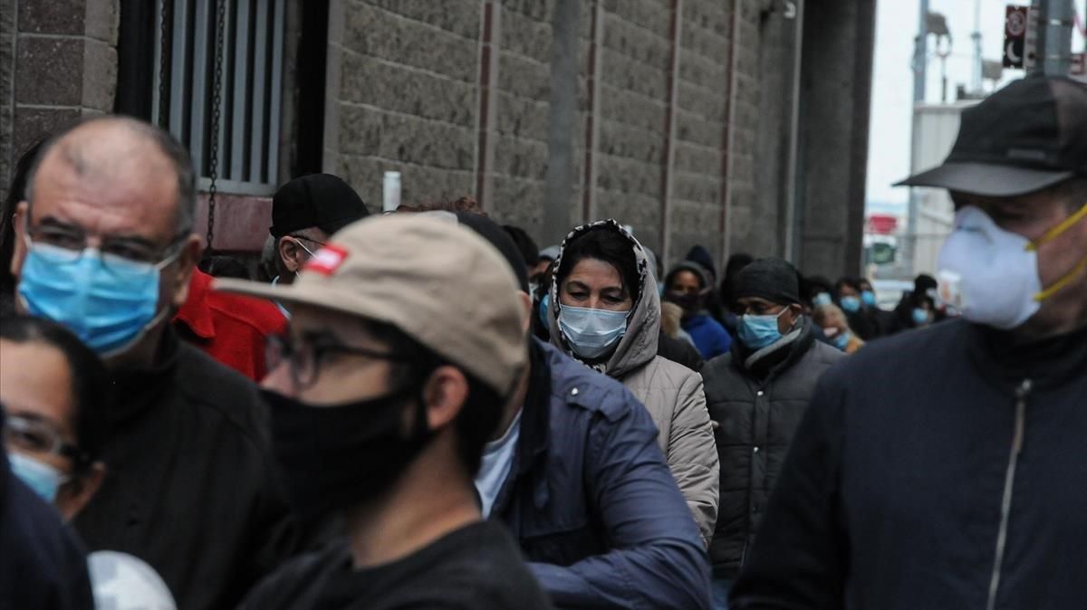 Un grupo de personas hace cola en Nueva York para ayuda social. Un grupo de personas hace cola en Nueva York para ayuda social.