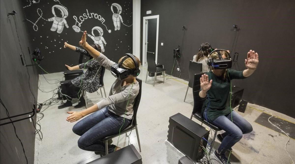 Cuatro jugadoras de ’Cosmos’, el ’escape room’ virtual de Lostroom, intentan volar sin despegar los pies del suelo. Lo que ellas están viendo: que son una panda de ’cyborgs’ en una estación espacial.   