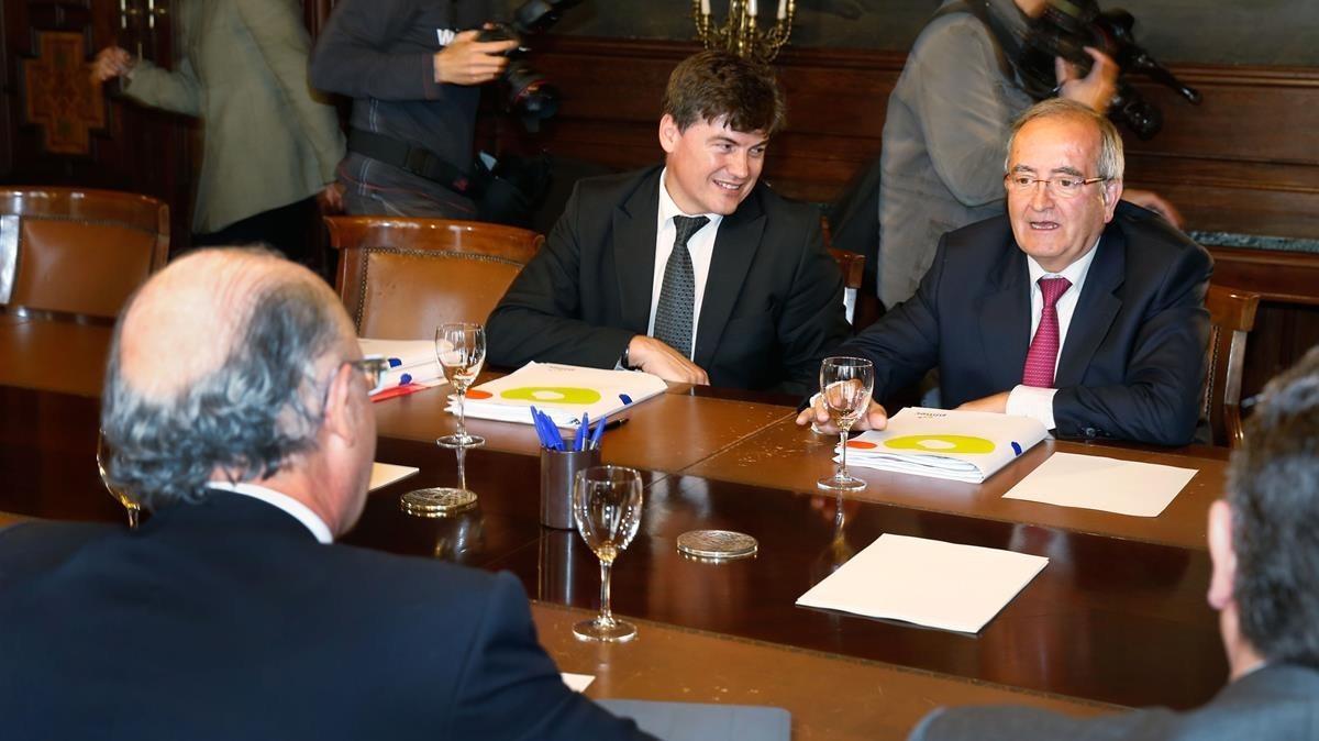 El presidente de la Plataforma contra la Morosidad, Antoni Cañete, en el centro, junto al presidente de Pimec, Josep González, en una reunión con el ministro de HAcienda, Cristóbal Montoro (de espaldas).