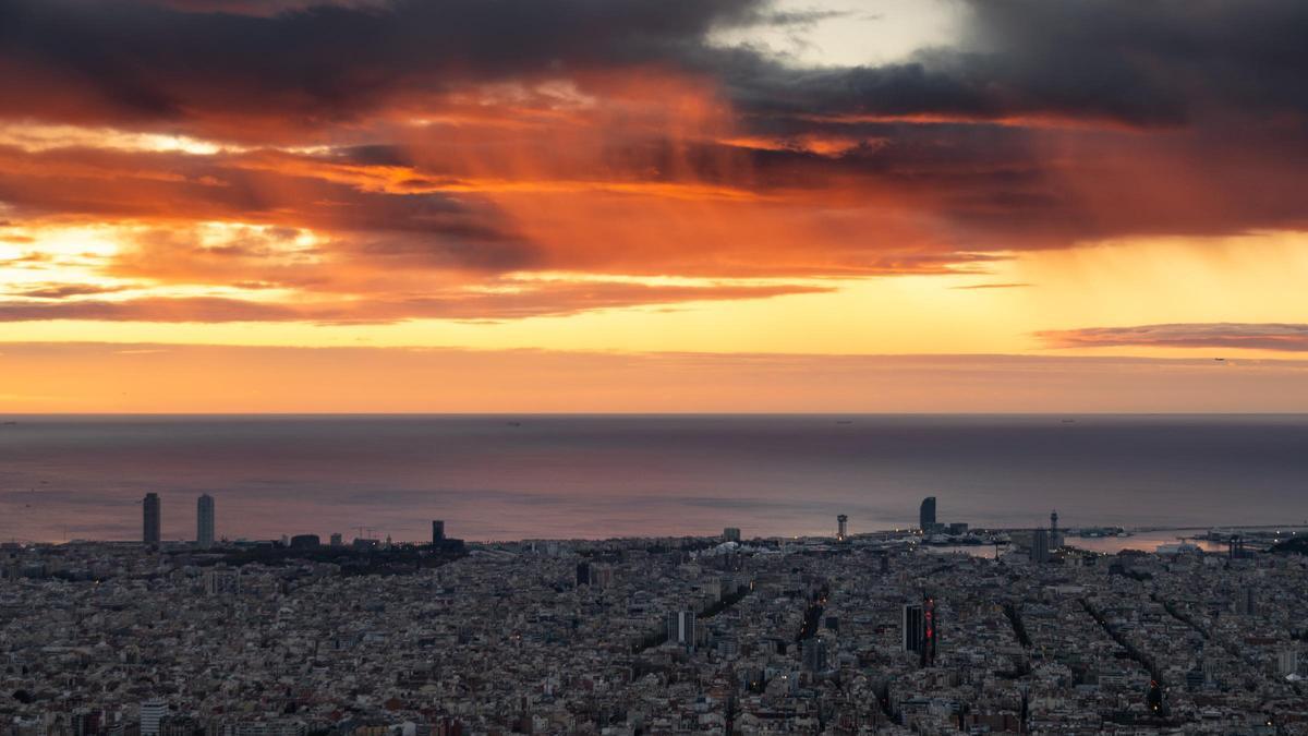 Una capa de estratocúmulos virga sobre el mar durante la salida del Sol en Barcelona