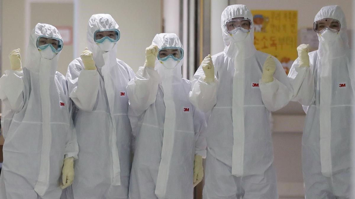 Trabajadores protegidos con trajes y máscaras en un centro médico de Bolivia.