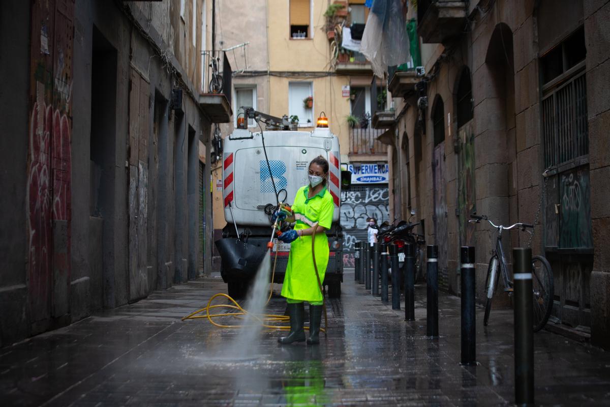 Una trabajadora limpia una calle de Barcelona.