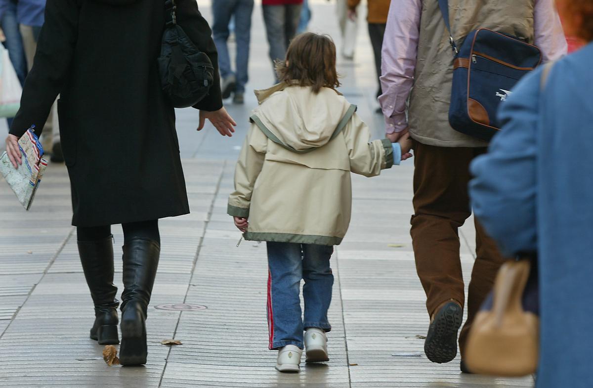 Padres llevando a la escuela a un niño. Padres llevando a la escuela a un niño.