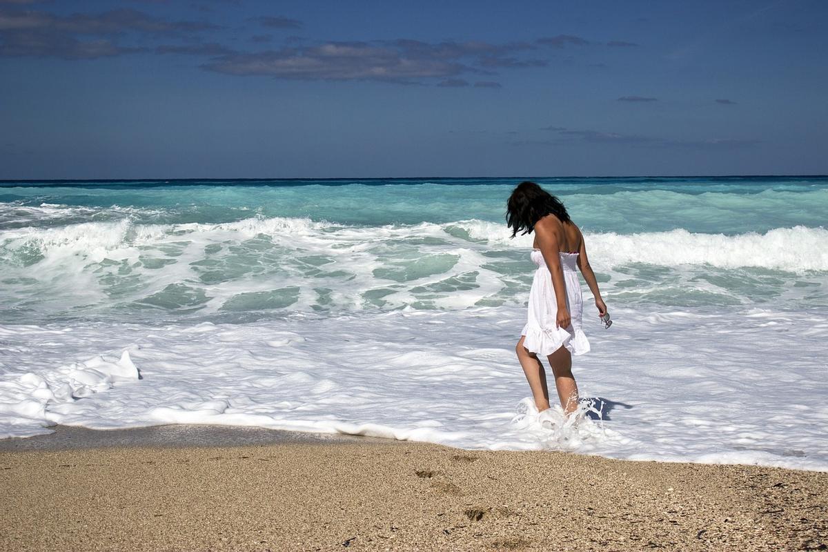 Una mujer pasea por la playa