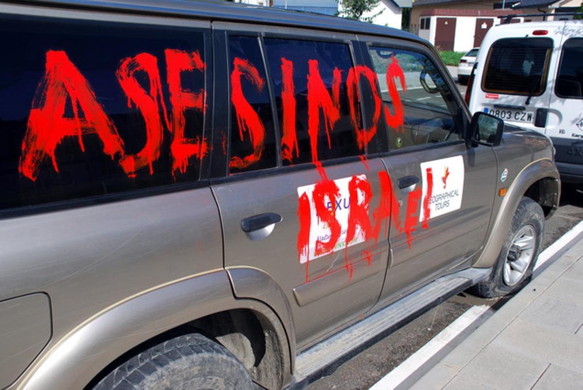 Un vehículo con pintadas y las ruedas pinchadas.