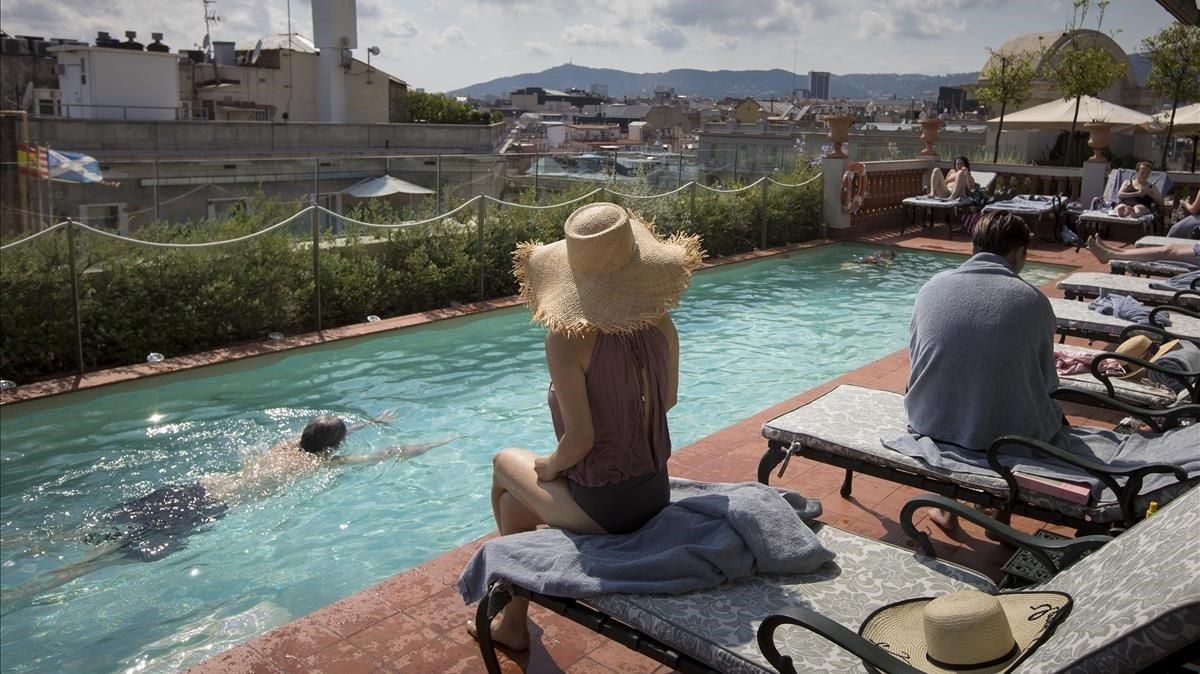 Clientes en la piscina situada en la azotea del Hotel Palace, en Barcelona. Clientes en la piscina situada en la azotea del Hotel Palace, en Barcelona.