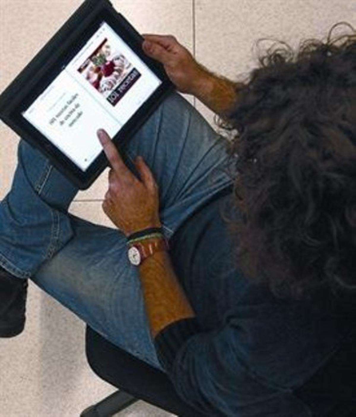 Un lector consulta el llibre electrònic ’101 recetas fáciles...’ en un iPad.